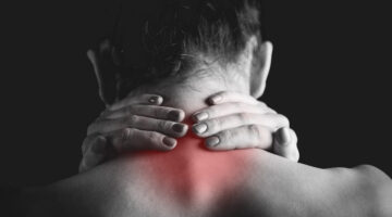 woman holding neck in pain