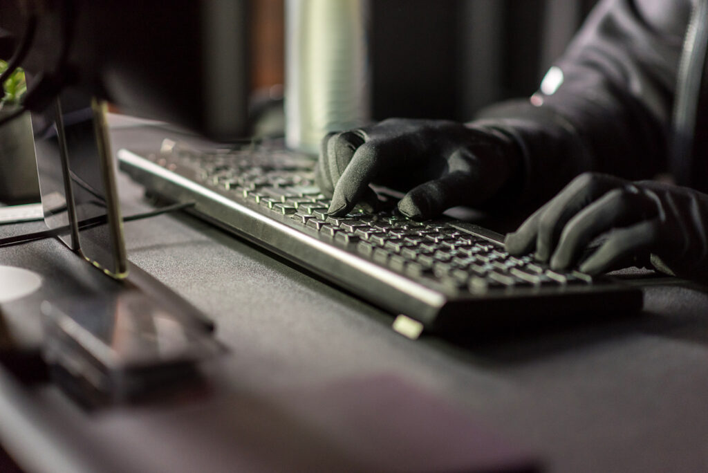 arms of hacker typing on keyboard