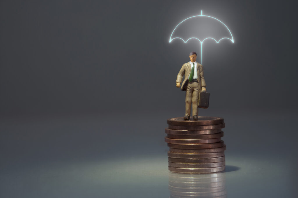 Miniature man standing underneath a lit up umbrella